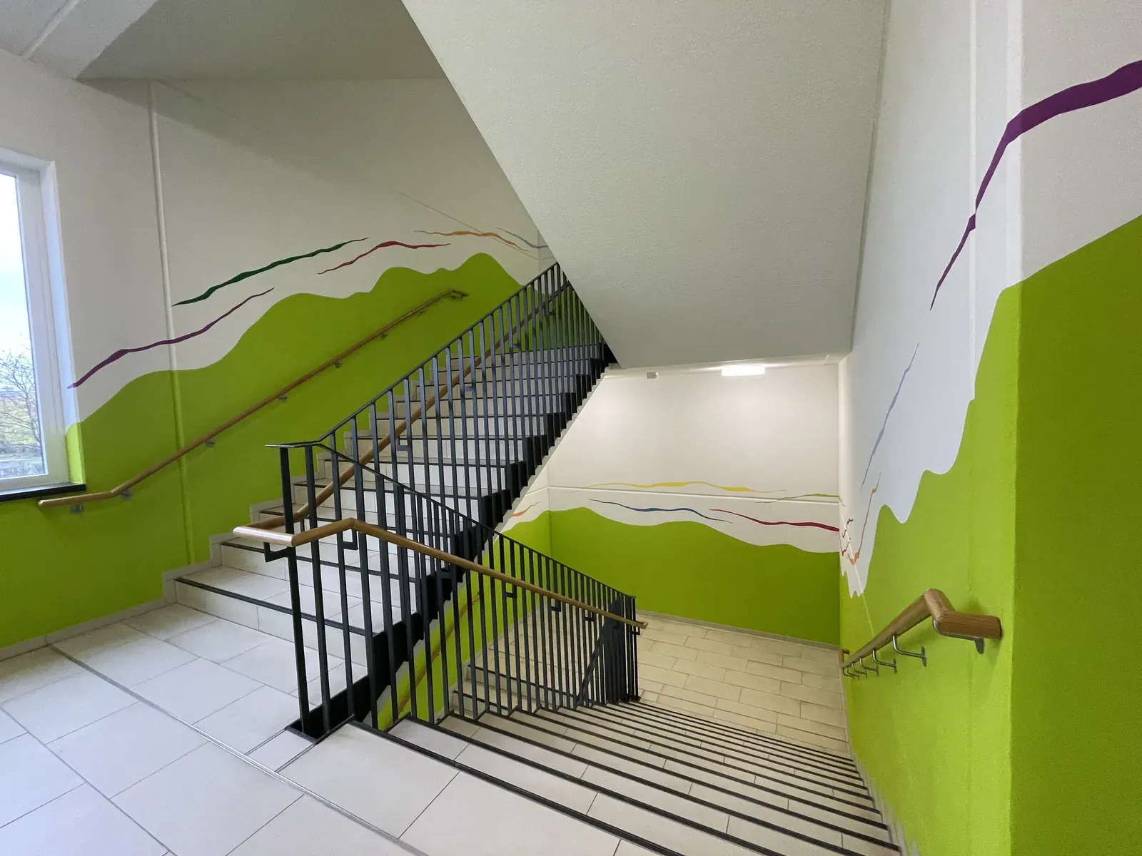 Treppenhaus mit grüner Wandgestaltung im Gemeindehaus